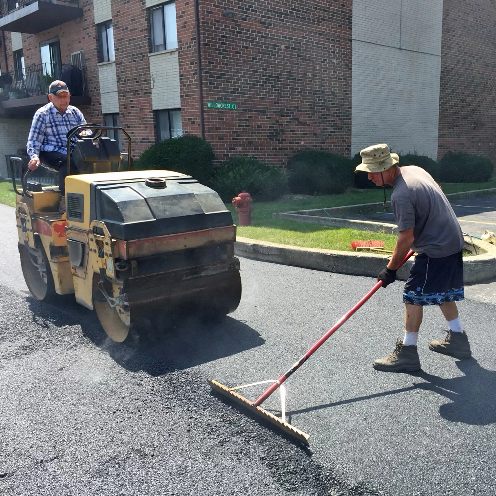 John Zarlengo Sr. and John Zarlengo Jr. paving new asphalt parking lot