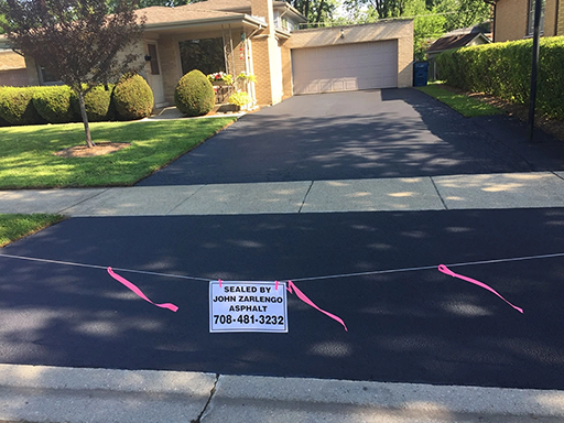 Residential driveway asphalt sealcoating in Chicago Heights, Illinois by John Zarlengo Asphalt Paving